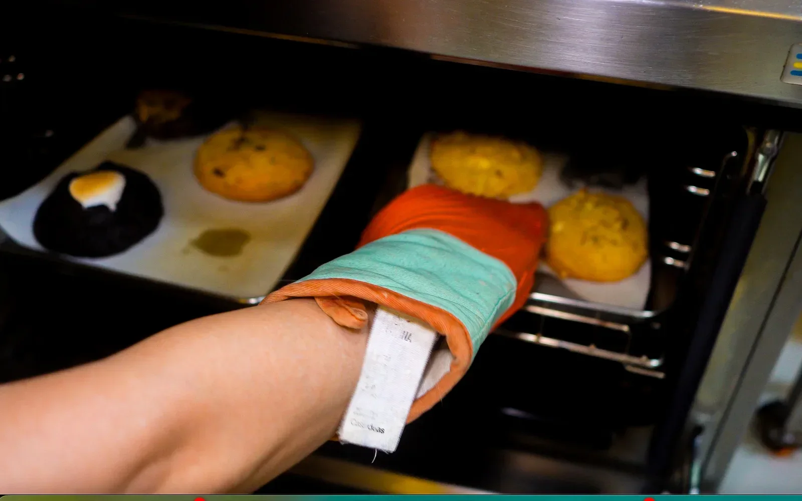 Bandeja de cookies en el horno manipulada con una manopla
